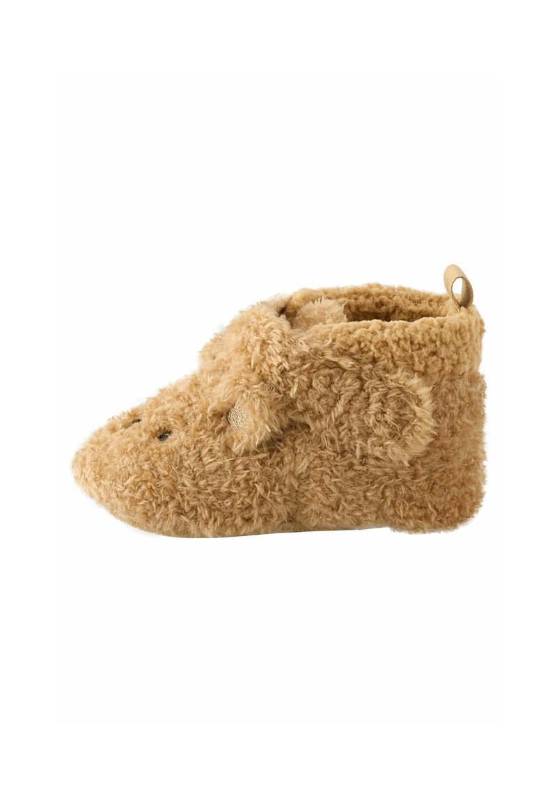 Pantoufles brunes en peluche avec un bout arrondi et une texture douce, arborant de petites oreilles et une languette à l'arrière pour un enfilage facile.