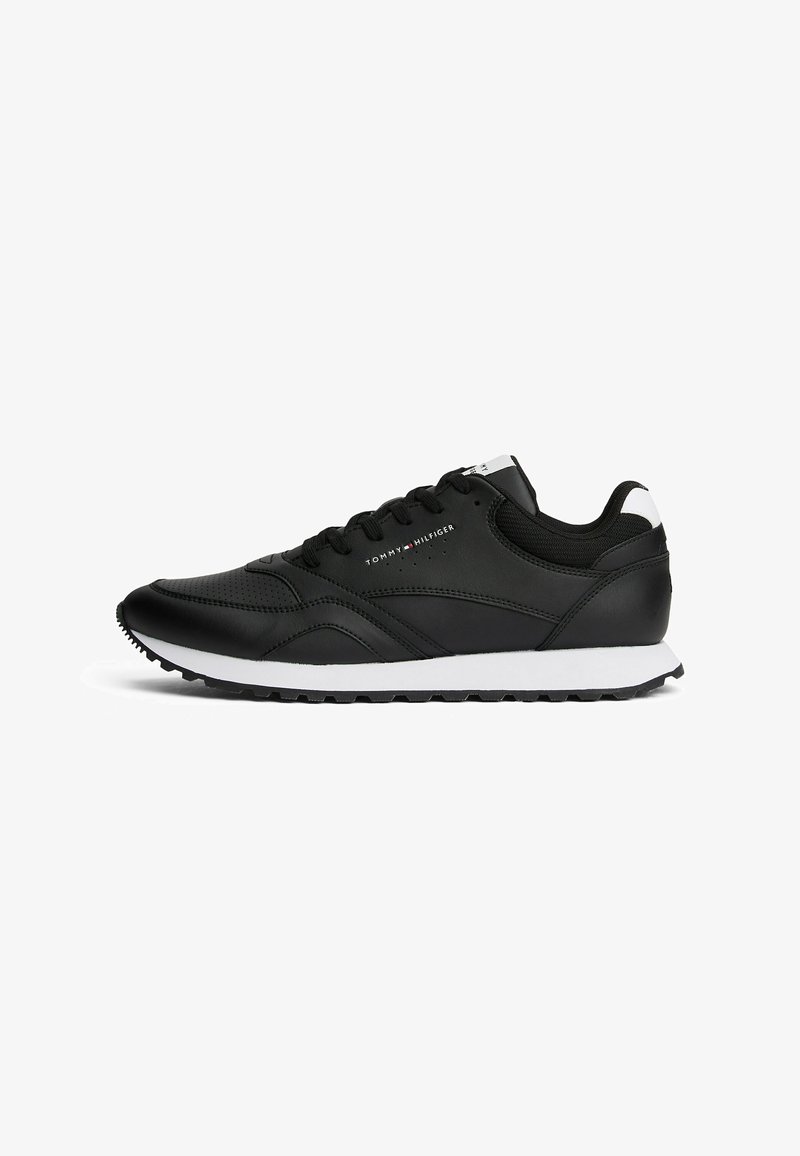 Black synthetic sneaker with a smooth texture, white midsole, laced design, and branding on the side. Features a slight arch and rubber outsole.