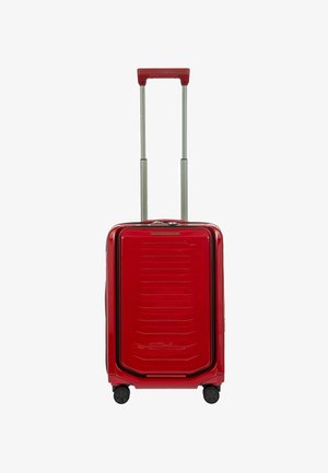 Valigia rigida rossa con finitura lucida, dotata di manico telescopico, quattro ruote e dettagli orizzontali a coste nella parte anteriore.