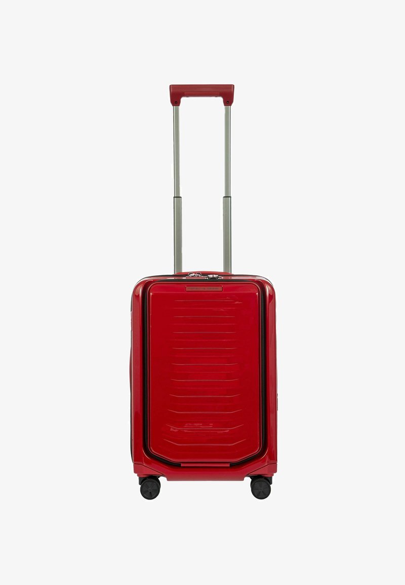 Valigia rigida rossa con finitura lucida, dotata di manico telescopico, quattro ruote e dettagli orizzontali a coste nella parte anteriore.