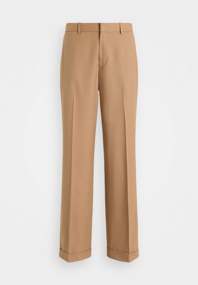Pantalons beige ajustés avec une coupe droite, fabriqués en tissu doux, dotés d'un pli avant et de poignets roulés au bas.