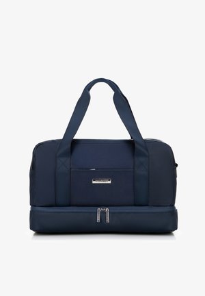 Marineblauwe sporttas met dubbele bovenhandvatten, textuurstof, een voorzak en een met rits afgesloten ondercompartiment. Details in zilverkleurig hardware.