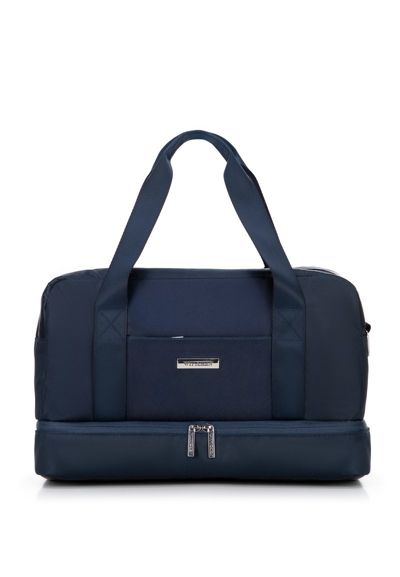 Marineblauwe sporttas met dubbele bovenhandvatten, textuurstof, een voorzak en een met rits afgesloten ondercompartiment. Details in zilverkleurig hardware.