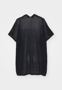 Svart, öppet stickat, kortärmat cardigan med en lös passform. Har ett vertikalt ribbmönster och rundad halsringning.