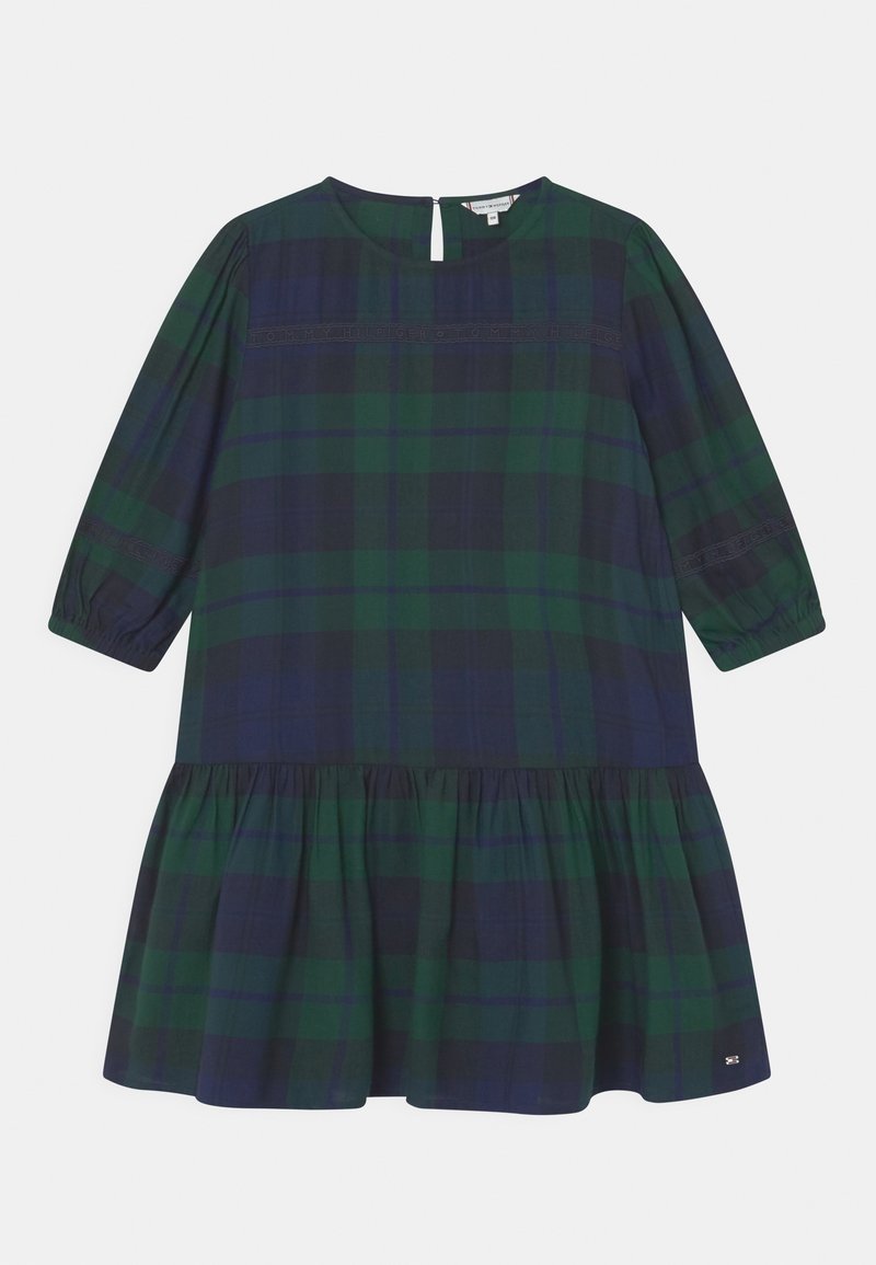 Zelené a námořnické kostkované šaty s kulatým výstřihem, tříčtvrtečními rukávy a rozšířeným volánkovým lemem. Obsahují klíčovou otvor vzadu.