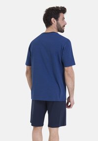 T-shirt rayé bleu pour homme en tissu doux, avec des manches courtes et un col rond, associé à un short noir anthracite.