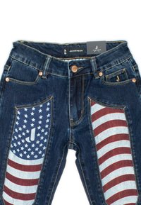 Jeans in denim blu scuro con pannelli a strisce rosse e bianche e motivo a stelle; completati con hardware dorato e etichetta del marchio.