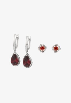 Orecchini con gemme rosse e dettagli in metallo argentato. Un paio presenta pietre a forma di pera, mentre l'altro ha pietre rotonde con montature circolari.