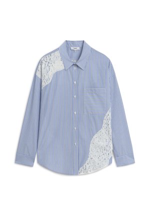 Camicia a righe blu e bianche con bottoni, caratterizzata da un'applicazione in pizzo sulla spalla sinistra, una tasca sul petto e maniche lunghe.