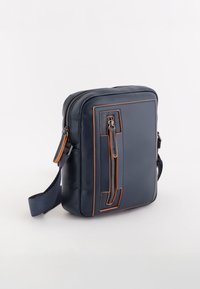 Námořnická kožená messenger taška s oranžovým prošíváním, přední kapsou na zip, nastavitelným popruhem a obdélníkovým tvarem. Hladký povrch, jednoduché kovové doplňky.