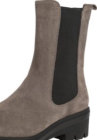Stivaletto in suede taupe con pannelli laterali elastici neri, dettagli di cucitura e suola in gomma testurizzata. Design semplice ed elegante per una facile vestibilità.