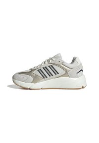Buty sportowe z szarym siateczkowym i zamszowym wierzchem, z trzema granatowymi paskami, grubą białą podeszwą środkową i gumową podeszwą.