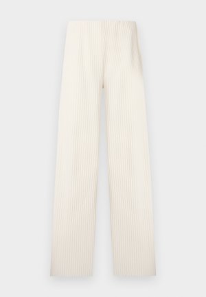 Pantaloni color crema a gamba larga con texture a coste verticali. Presentano una cintura senza cuciture, senza elementi visibili o dettagli. Sagoma dritta.