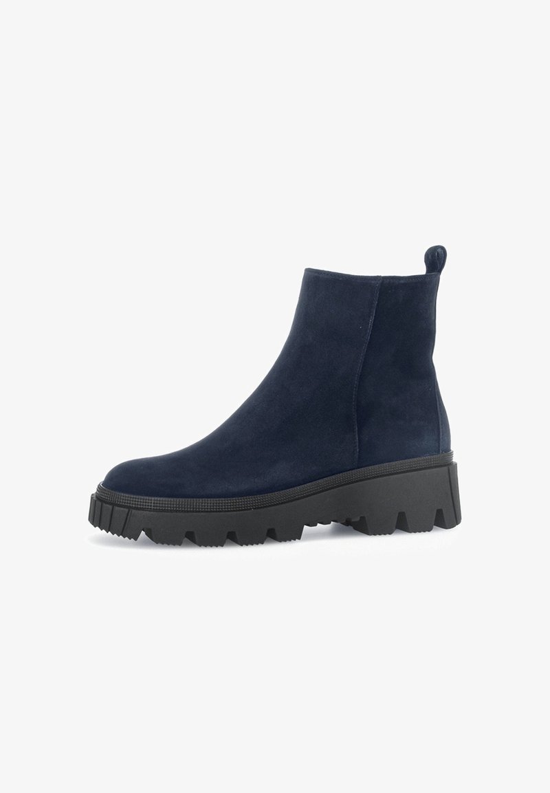 Bottes courtes en daim bleu marine avec une semelle épaisse en caoutchouc noir, présentant un bout arrondi et une languette à l'arrière pour un enfilage facile.