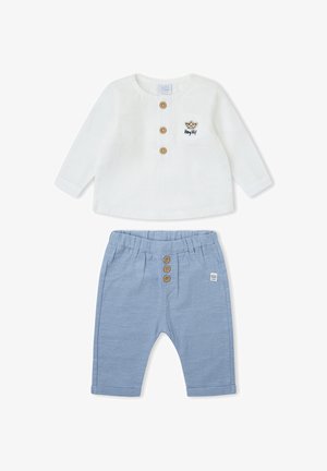 Camiseta blanca de manga larga para bebé con botones de madera y bolsillo, combinada con pantalones a rayas azul claro con botones de madera.