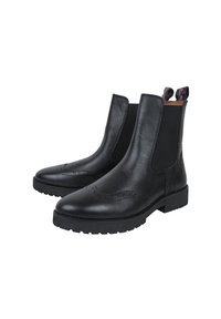 Bottines Chelsea en cuir noir avec des panneaux élastiques sur les côtés, des détails en brogue et des languettes de traction avec une touche de couleur. Semelles en caoutchouc épaisses.