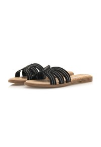 Las sandalias negras de diapositivas cuentan con tiras curvadas con detalles texturizados, una suela plana de color marrón claro y un diseño de punta abierta para mayor transpirabilidad.