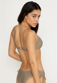 Brun bikiniuppsättning med en triangelöverdel med tunna justerbara band och en matchande underdel med sidoknytning och en rynkad textur.