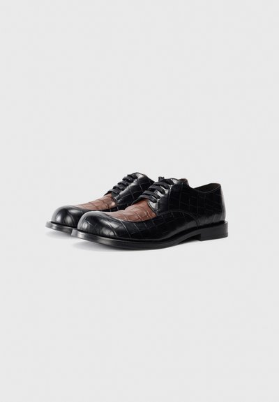 Black and brown leather shoes featuring a crocodile texture, round toe, lace-up design, and contrasting panels on the upper.