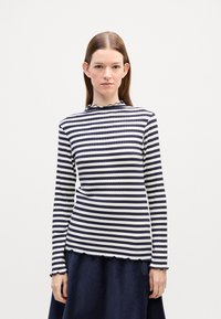 Langärmliges geripptes Oberteil mit marineblauen und weißen horizontalen Streifen, das über einen gewellten Halsausschnitt und Saum verfügt.
