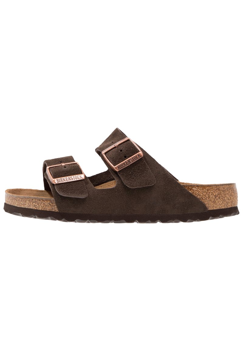 Sandales en daim marron avec deux brides réglables, boucles en métal cuivre, semelle en liège et semelle extérieure en caoutchouc texturé.