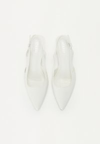 Talons hauts slingback en cuir blanc avec un bout pointu, des côtés ouverts et une petite fermeture éclair à l'arrière. Texture lisse et design minimaliste.