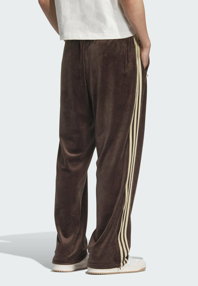 Bruine velours broek met een losse pasvorm, voorzien van crèmekleurige zijstrepen, een elastische tailleband en zijzakken. Gestructureerde stof.