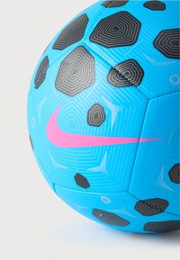 Μπλε ποδοσφαιρική μπάλα με μαύρα γεωμετρικά σχέδια και ροζ λογότυπο της Nike· κατασκευασμένη από συνθετικό υλικό, με υφή στην επιφάνεια και εξαγωνικά πάνελ.