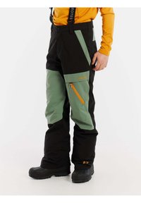 Pantaloni da neve neri e verdi con tasca con zip arancione, spalline regolabili e vestibilità larga, progettati per attività in condizioni di freddo.