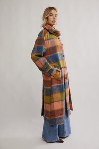 Casaco xadrez multicolorido feito de lã, com gola larga, fecho de botões e bolsos laterais. As cores incluem laranja, azul e verde.