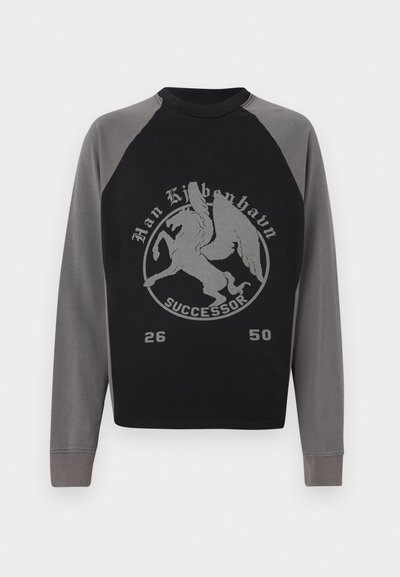 Black and gray sweatshirt with raglan sleeves, featuring a prominent silver graphic of a winged lion and text "SUCCESSOR 26 50." Soft fabric.