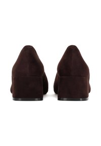 Hnědé semišové boty na blokovém podpatku s designem špičatého nosu. Podpatky jsou přibližně 5 cm vysoké a mají hladkou černou základnou.