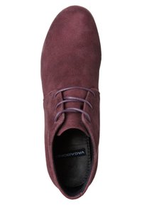 Zapato de ante burdeos con puntera redondeada, cordones planos y diseño minimalista. En el interior tiene un forro negro con la etiqueta de la marca visible.