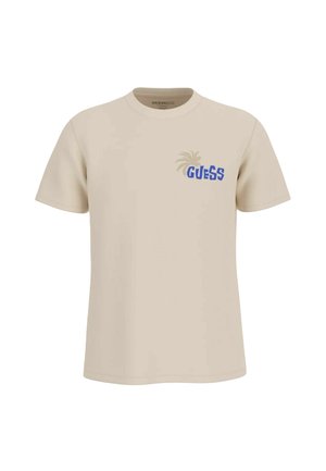 Maglietta beige a maniche corte con testo "GUESS" blu e grafica di palma chiara sul petto a sinistra, stile girocollo.