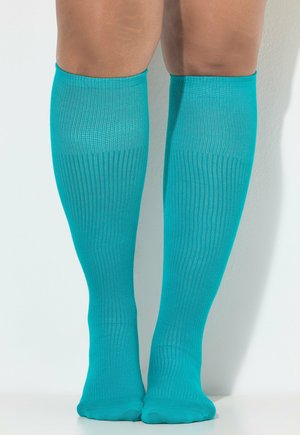 Türkise kniehohe Socken aus einem glatten, dehnbaren Material mit einer gerippten Textur, die eng an den Beinen anliegen.