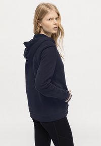 Marinblå hoodie med dragsko i huvan, kängurufickor, ribbstickade muddar och nederkant. Mjuk tyg med en slät yta, utformad för komfort.