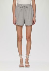 Shorts gris légers avec une taille élastique et un cordon de serrage. Dotés d'un tissu texturé et d'une coupe décontractée, se terminant au milieu de la cuisse.