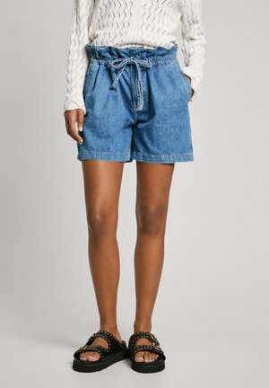Denim shorts med elastisk talje og snor. Blå farve med en afslappet pasform. Båret med sorte sandaler med gyldne nitter.