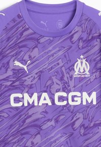 Maglia sportiva viola con motivo astratto, caratterizzata da loghi bianchi di Puma e Marsiglia, e grande testo bianco "CMA CGM" sulla parte anteriore.