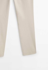 Beige lichte broek met een gladde textuur, getailleerde pasvorm en rechte pijpen. Geen zichtbare patronen of accenten, minimalistisch ontwerp.
