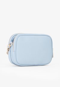 Borsa rettangolare di colore azzurro chiaro in pelle testurizzata con cerniere e hardware dorati. Design a doppio scomparto con bordi arrotondati.