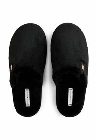Zapatillas de casa negras, de felpa, con una textura suave, diseño de espalda abierta y un acento de logo dorado. Cuentan con una plantilla de marca con rayas de colores contrastantes.