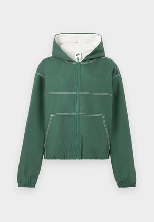 Sudadera con capucha verde con cremallera, forro blanco, costuras blancas, capucha con cordón y dos bolsillos delanteros.
