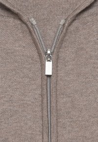 Reißverschluss-Pullover aus hellem braunem Strickstoff. Verfügt über einen silbernen Reißverschluss mit einer Lasche oben und gerippten Kanten am Kragen und Reißverschluss.