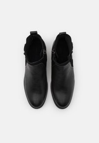 Botas de cuero negro hasta el tobillo con acabado texturizado, que cuentan con cremalleras laterales dobles y punta redonda, diseñadas para un uso fácil.