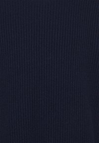 Marineblaues geripptes Strickmaterial mit einer strukturierten Oberfläche und vertikalen Linien, die ein einheitliches und gleichmäßiges Muster erzeugen.