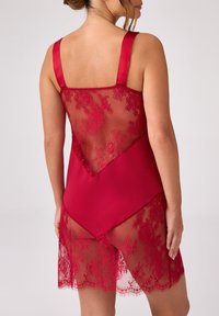 Czerwona bielizna z satynowym przodem i tyłem z siateczki z kwiatowej koronki, z regulowanymi ramiączkami i warstwowym dołem. Przezroczyste koronkowe akcenty.