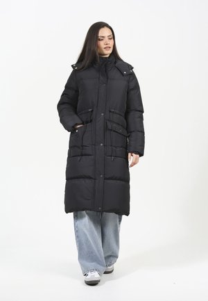 Cappotto puffer lungo nero con colletto alto, bottoni a pressione frontali e cordini regolabili in vita; tessuto testurizzato e isolante.