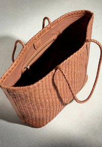 Grand sac fourre-tout en cuir tissé beige avec deux poignées, ouverture supérieure, intérieur en tissu clair et une poche intérieure zippée.