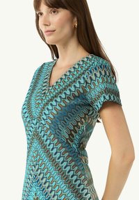 Abito con motivo caratterizzato da scollatura a V, maniche corte e un design a zigzag in tonalità di blu e marrone, realizzato in un tessuto morbido e leggero.